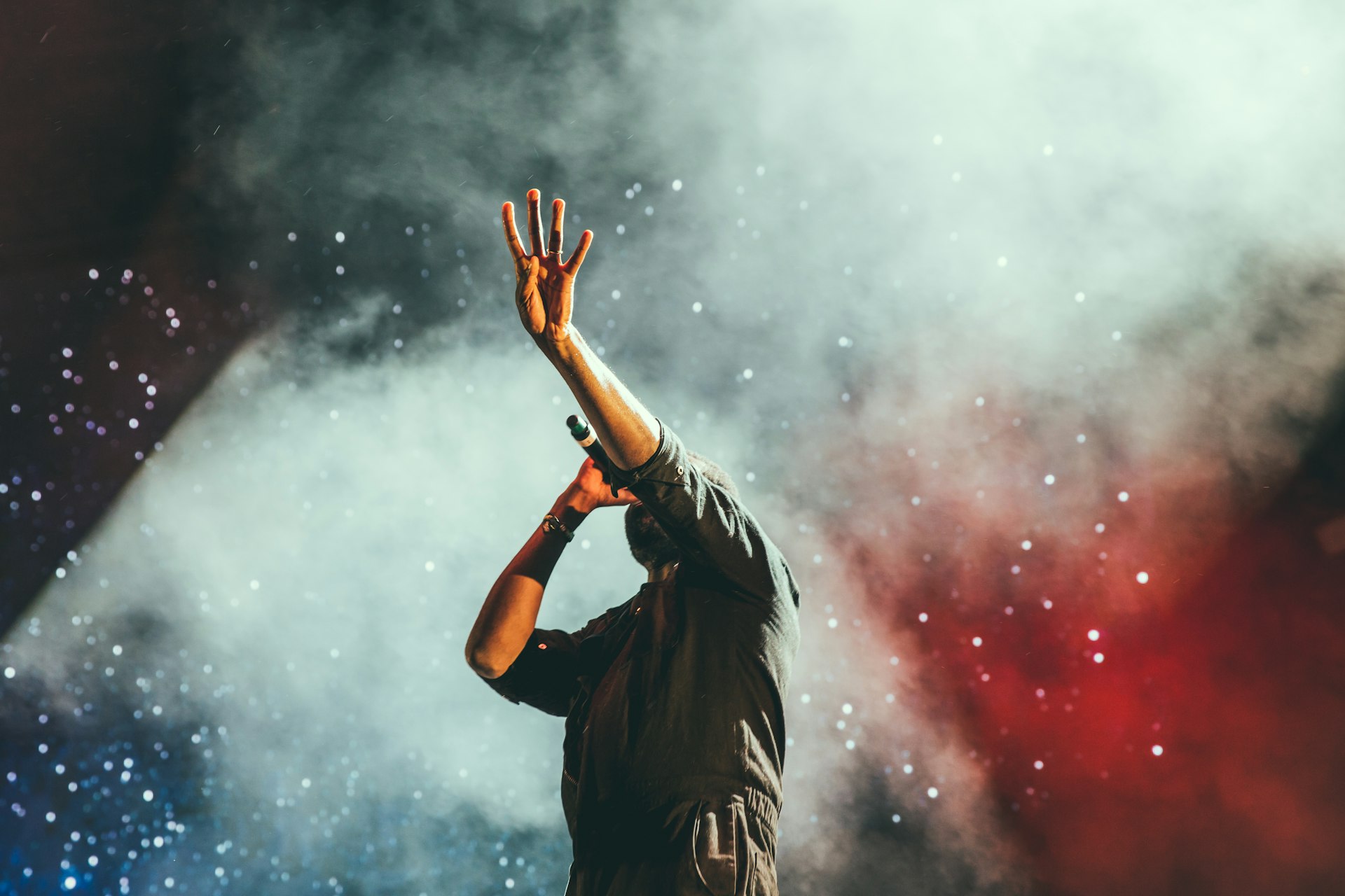 Festival crowd with arms raised as confetti falls